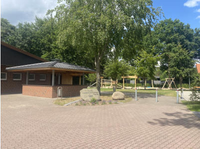 Außenansicht des Dorfgemeinschaftshauses mit Spielplatz