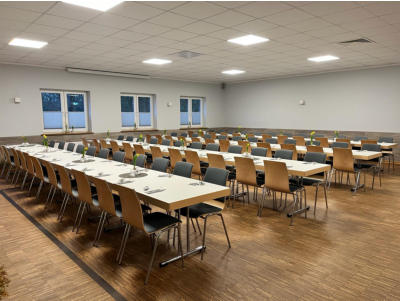Festlich gedeckter Saal mit langen Tafeln